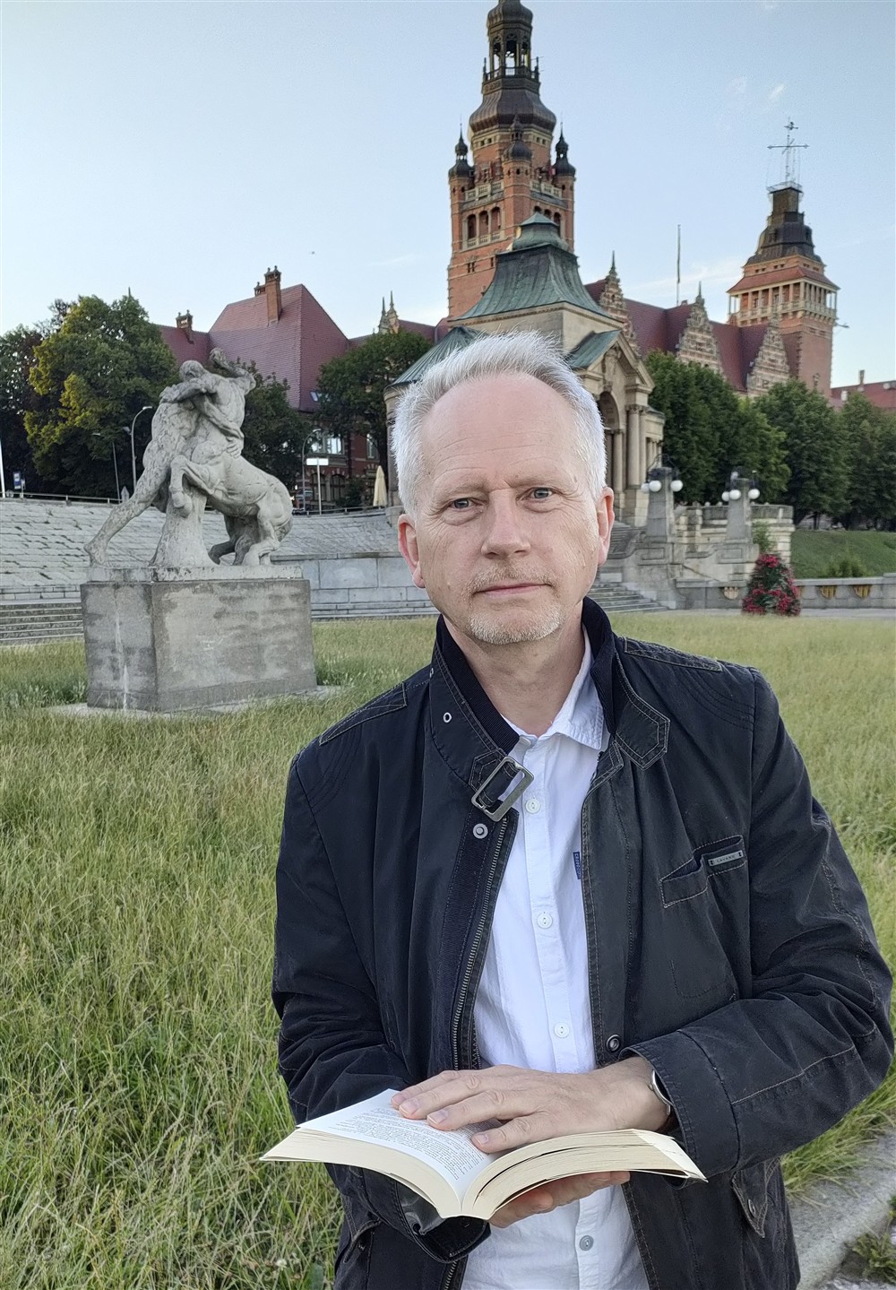 Robert Baciocha z książką na tle Szczecina